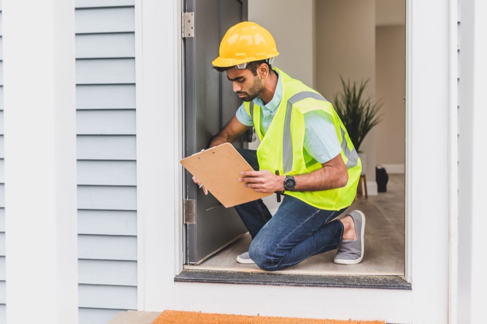 A certified inspector examining a home's window and trim for lead-based paint